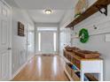Bright foyer with hardwood floors, a white front door, and decorative shelving with storage at 7452 Lace Bark Ct, Avon, IN 46123