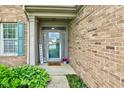 Inviting front entrance with a green door, sidelights, and a 'Welcome' sign, surrounded by lush greenery at 7452 Lace Bark Ct, Avon, IN 46123