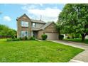 Charming brick home with attached garage, green shutters, and a lush, well-maintained lawn at 7452 Lace Bark Ct, Avon, IN 46123