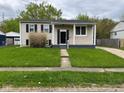Traditional home boasts a neatly kept yard, inviting porch, and symmetrical design at 7514 Ruskin Pl, Indianapolis, IN 46226