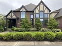 Charming two-story home with manicured lawn and beautiful garden beds at 7661 Carriage House Way, Zionsville, IN 46077