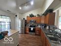 Well-lit kitchen featuring stainless steel appliances, wood cabinets, and a breakfast bar island at 7733 Sergi Canyon Dr, Indianapolis, IN 46217