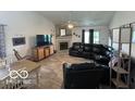 Spacious living room with a fireplace, comfortable black leather seating, and hardwood-style floors at 7733 Sergi Canyon Dr, Indianapolis, IN 46217