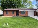 Charming brick home with an attached garage and a well-manicured front lawn at 7842 Brennan Rd, Indianapolis, IN 46219