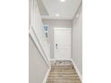 Bright entryway featuring hardwood floors, white stairs, and a door with modern hardware at 8266 Glacier Ridge Dr, Fishers, IN 46038