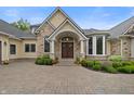 Charming entrance showcasing an arched entryway with double doors, manicured landscaping and a brick driveway at 860 Chatham Hills Blvd, Westfield, IN 46074