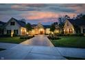 Beautiful twilight view of a home with a brick driveway, professional landscaping and inviting outdoor lighting at 860 Chatham Hills Blvd, Westfield, IN 46074