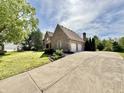 Exterior view of a home with a long concrete driveway leading to a two-car garage in a suburban neighborhood at 897 Copperwood Dr, Carmel, IN 46033