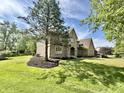 Classic brick home with a well-manicured lawn and mature trees provides a picturesque and welcoming curb appeal at 897 Copperwood Dr, Carmel, IN 46033