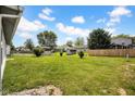 Spacious backyard featuring green grass, storage sheds, and a wood fence at 905 Congressional Way, Shelbyville, IN 46176