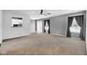 Open living room featuring carpet floors and natural light with grey walls and modern curtains at 905 Congressional Way, Shelbyville, IN 46176