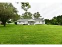 Expansive backyard with lush green lawn, mature trees, and a detached garage at 9098 W 1050 N, Elwood, IN 46036