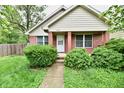 Charming brick home featuring a well-maintained front yard with mature trees and lush landscaping at 924 S B St, Elwood, IN 46036