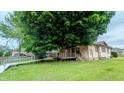 Charming single-story home with large mature shade tree and wooden ramp to the covered porch at 100 N 6Th Ave, Beech Grove, IN 46107
