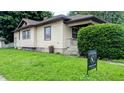 View of the side of a lovely home with a well-kept lawn and professional real estate signage at 100 N 6Th Ave, Beech Grove, IN 46107