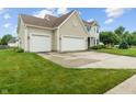 Well-maintained home with a three-car garage, lush green lawn and mature landscaping at 1029 Bridgeport Dr, Westfield, IN 46074