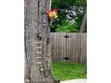 Unique backyard decor, including a decorated tree with flowers and miniature ladder at 1114 N Olney St, Indianapolis, IN 46201