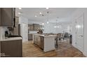 Open-concept kitchen with stainless steel appliances and a center island, flowing into the dining and living areas at 14866 E Keenan Cir # Lot 38, Westfield, IN 46074