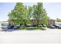 A traditional brick building with mature trees, black shutters, and ample parking at 1602 Queensbridge Sq # 7, Indianapolis, IN 46219