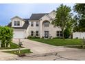 Charming two-story brick home with well-manicured lawn and a spacious driveway at 1713 Williamsburg Cir, Franklin, IN 46131