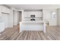 Bright kitchen featuring an island, wood grain flooring, stainless steel appliances, and white cabinets at 18967 Seaforth Way, Westfield, IN 46074