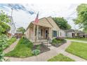 Inviting single-Gathering home featuring a quaint front porch, lush lawn, and a classic American flag at 1913 Pennsylvania St, Columbus, IN 47201