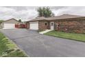 View of the home's driveway, detached garage, and brick exterior at 2010 Alexandria Dr, Greenfield, IN 46140