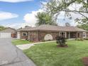 Spacious home showcasing a detached garage, brick construction, and a lush green lawn at 2010 Alexandria Dr, Greenfield, IN 46140