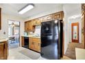 Efficient kitchen featuring ample wood cabinetry and black appliances with an adjoining dining space visible at 2110 Fisher Ave, Speedway, IN 46224