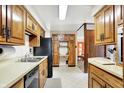 Functional kitchen with wood cabinets, black appliances, and a view into other rooms of the house at 2110 Fisher Ave, Speedway, IN 46224