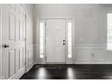 Bright entryway with hardwood floors, a white door with sidelights, white trim, and neutral colored walls at 2209 S Logan Dr, New Palestine, IN 46163
