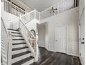 Spacious foyer with staircase featuring white railing and dark wood steps, beautiful floors, and neutral walls at 2209 S Logan Dr, New Palestine, IN 46163