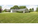 Single story home with a one car garage surrounded by a large manicured lawn and mature trees at 3020 E 400 S, Lebanon, IN 46052