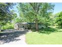 Scenic shot of a home featuring mature trees, detached garage, and a driveway, blending nature and convenience at 4023 Cedar Hills South Dr, Greenwood, IN 46143