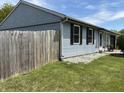 Exterior showing the blue siding of the home, black shuttered windows and a wooden fence at 5117 Bahia Dr, Indianapolis, IN 46237