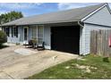Exterior view of home showing blue siding, a black garage door and small seating area at 5117 Bahia Dr, Indianapolis, IN 46237