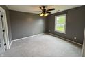 Cozy bedroom with neutral carpet, a ceiling fan, and a bright window at 660 White Ash Trail, Mooresville, IN 46158