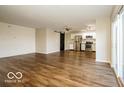 Open concept living area with hardwood floors, slider to deck, and views into the kitchen with stainless appliances at 6756 Wimbledon Dr, Zionsville, IN 46077