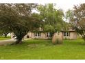 Residential house with a well-kept front yard and mature shade trees, showcasing its curb appeal at 7214 W Reformatory Rd, Fortville, IN 46040