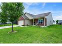 Inviting single-story home boasting a brick accent, attached garage, and lush green yard at 7238 Moultrie Dr, Indianapolis, IN 46217
