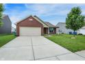 Lovely single-story house with a brick front, attached garage, and green lawn at 7238 Moultrie Dr, Indianapolis, IN 46217