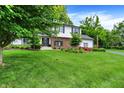 Inviting two-story home with lush green lawn, mature trees, and professionally landscaped flower beds at 7255 Haverhill Ct, Indianapolis, IN 46250
