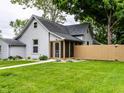 Quaint home featuring gray siding, a well-maintained lawn, a screen porch, and a painted wood fence at 7536 Mccord St, McCordsville, IN 46055