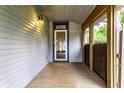Enclosed front porch featuring a wood deck, sidelight windows and a white storm door at 7536 Mccord St, McCordsville, IN 46055