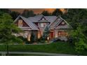 Stunning brick home illuminated at twilight showcasing its landscaping and design at 7744 Preservation Dr, Indianapolis, IN 46278