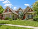 Charming brick home with a well-maintained lawn and vibrant landscaping at 7744 Preservation Dr, Indianapolis, IN 46278