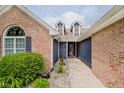 Charming home featuring brick accents, blue siding, dormer windows, and a well-maintained walkway at 7838 Chesapeake E Dr, Indianapolis, IN 46236