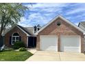 Beautiful brick home with a well-kept lawn and an attached two-car garage at 7838 Chesapeake E Dr, Indianapolis, IN 46236