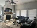 Cozy living room showcasing a fireplace, plush sofas, and a modern ceiling fan at 7838 Chesapeake E Dr, Indianapolis, IN 46236