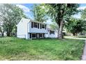 A charming two-story home shows off its backyard from the side with blue siding and a sprawling green lawn at 7915 Broadview Dr, Indianapolis, IN 46227